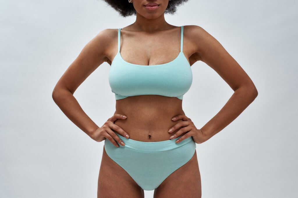 Cropped shot of curvy woman in teal underwear with her hands on hips